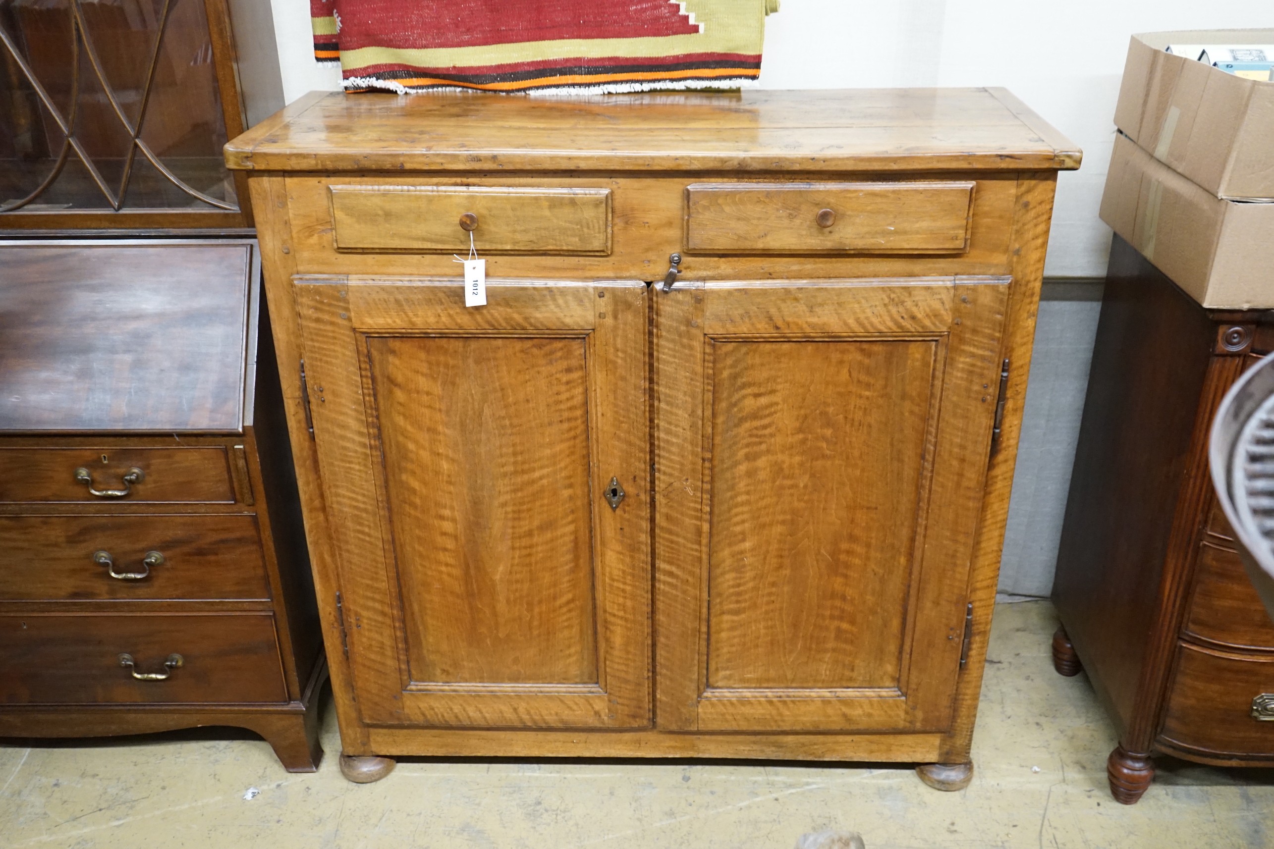 A late18th century continental fruitwood two drawer side cabinet, width 128cm, depth 47cm, height 128cm